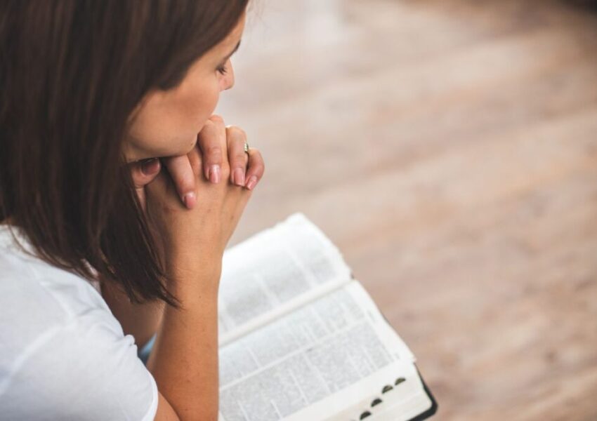 The woman solemnly prays every morning.