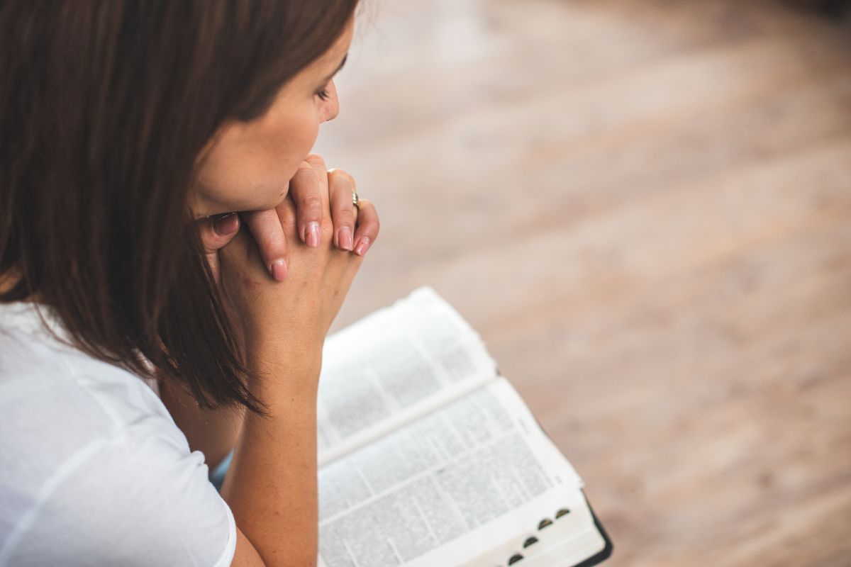 The woman solemnly prays every morning.