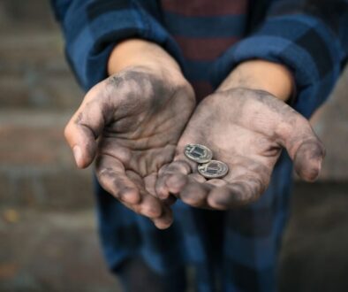 A poor widow holding two small coins.