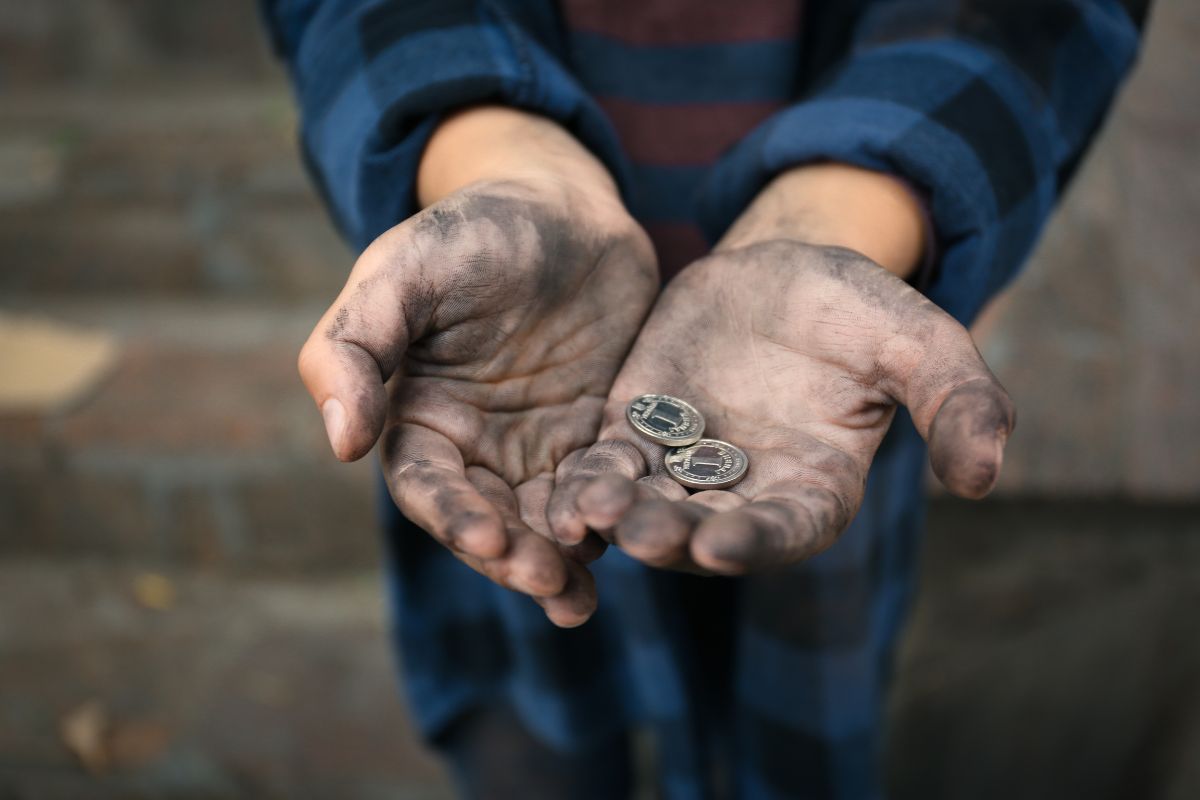 A poor widow holding two small coins.