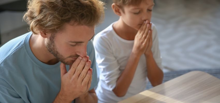 The father and son is praying solemnly every friday.