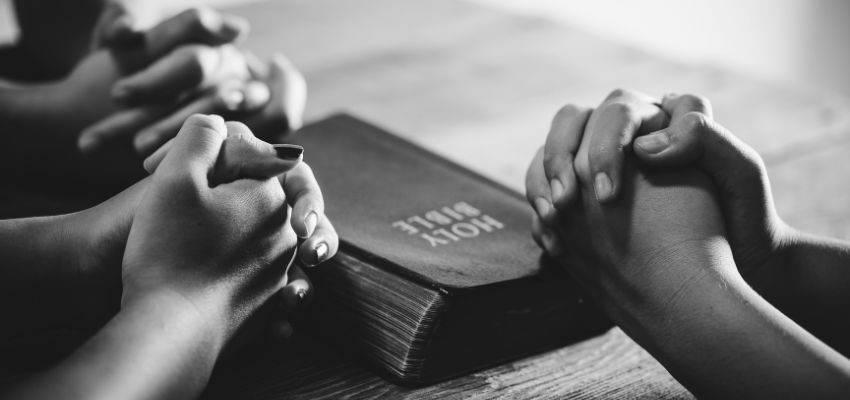 The group of people pray after reading the scriptures about anxiety.