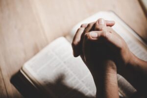 The man prays after reading gospel verses in the bible.