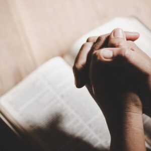 The man prays after reading gospel verses in the bible.