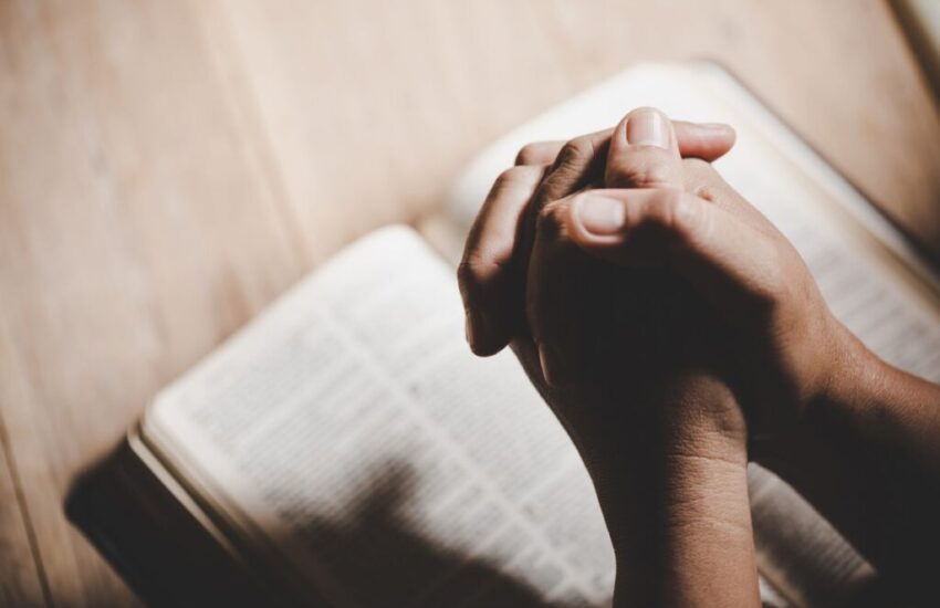 The man prays after reading gospel verses in the bible.