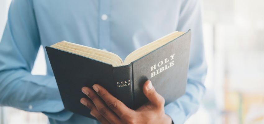 The man is reading the bible for spiritual contemplation.