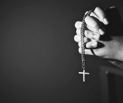 Hands holding a rosary with a cross, symbolizing faith and miracle prayer.