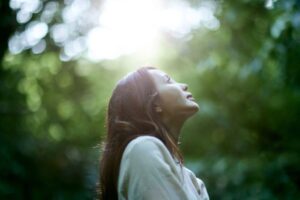 A woman practicing contemplative techniques like silent prayer in a peaceful environment.