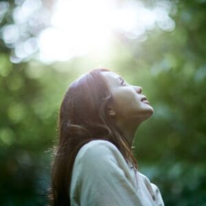 A woman practicing contemplative techniques like silent prayer in a peaceful environment.