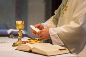 A priest prepares the Eucharist.