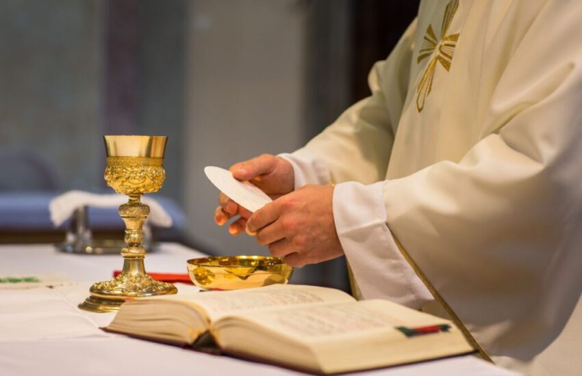A priest prepares the Eucharist.