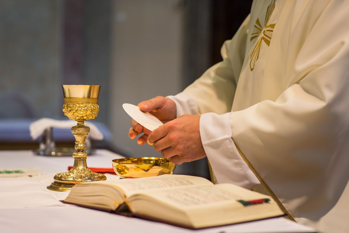 A priest prepares the Eucharist.