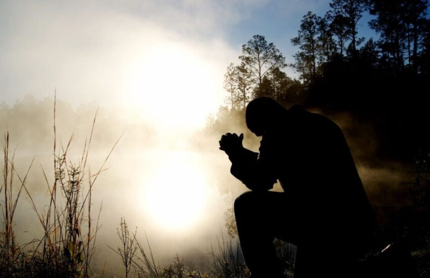 A man is praying devoutly on his knees.