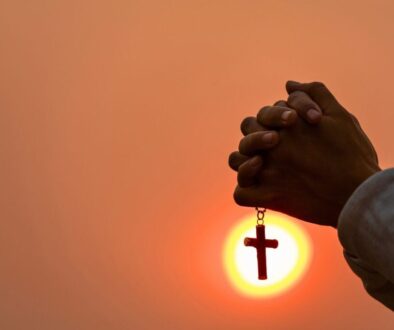 The man holds a rosary while praying, showing faithfulness to God.