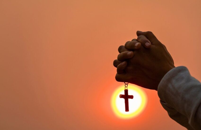 The man holds a rosary while praying, showing faithfulness to God.