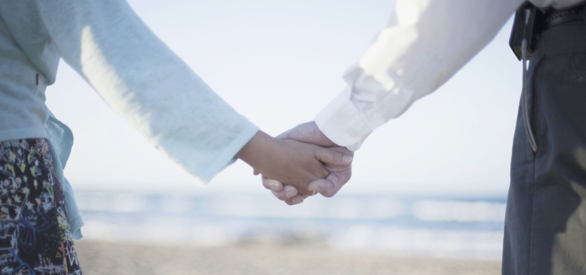 Couple holding hands on the beach, reflecting the romantic themes in song solomon verses