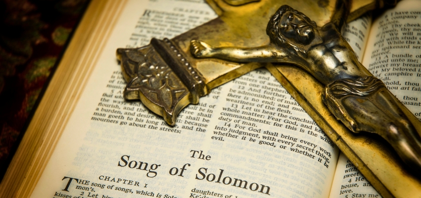 Close-up of an open Bible showing the title page of song solomon verses