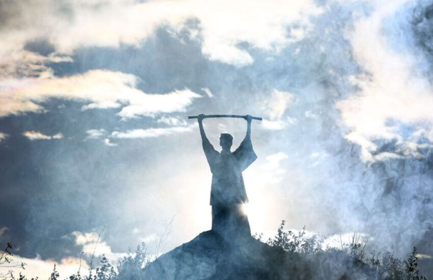 Moses holds up his staff.