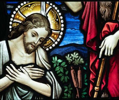 Jesus being baptized as an image on a stained glass window.