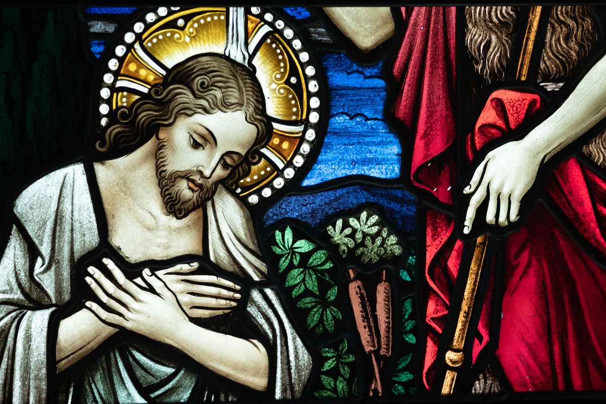 Jesus being baptized as an image on a stained glass window.