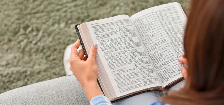 Close-up of hands reading an open Bible, ideal for bible verses for mothers