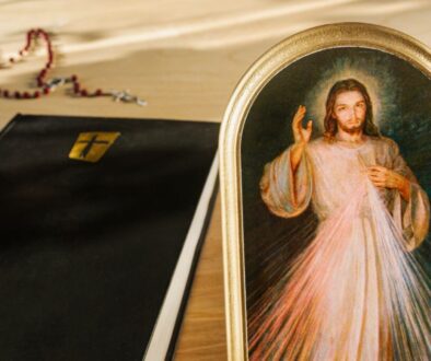 The Divine Mercy image beside a bible and rosary.
