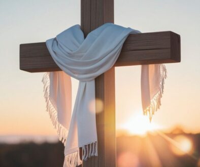 The sun rises behind a cross.