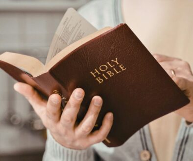 Person holding and reading the Holy Bible, exploring bible stories that relate to everyday life