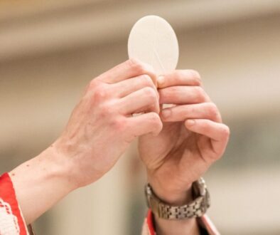 A priest holds up the Eucharist during Mass.