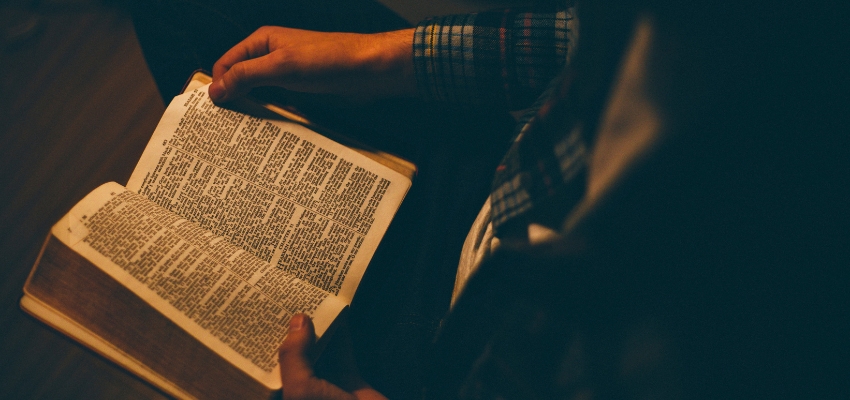 Person reading an open Bible, finding hope and encouragement with bible verses for discouragement