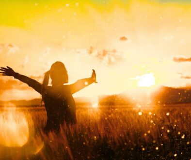 A woman experiences refreshment of her soul in a field during sunset.
