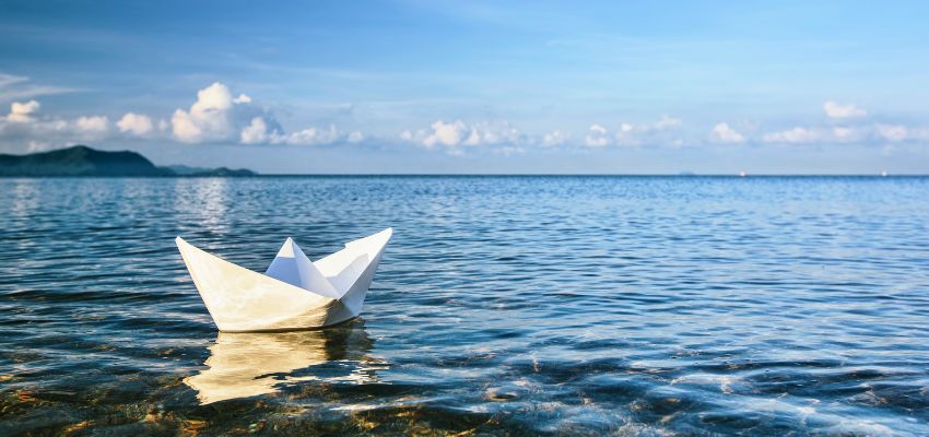 Paper boat on still water symbolizing release through Prayers to Free You From Anger and Resentment.